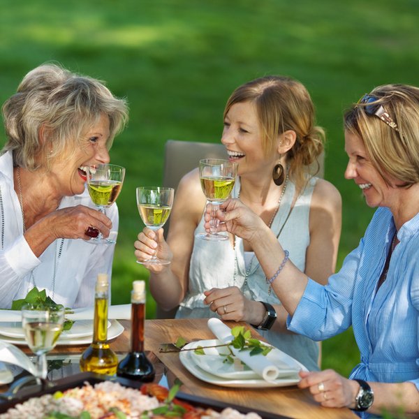 Familie trinkt im Garten Wein