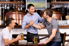 Männer treffen sich in einer Bar und trinken Bier