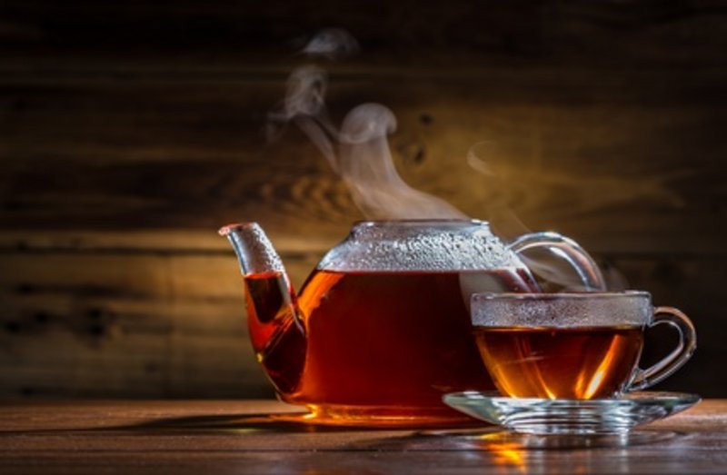 Durchsichtige Teekanne und Teetasse gefüllt mit Tee